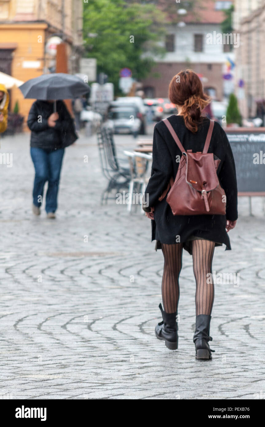 Donna che cammina sulla strada. La gente reale. Vista da dietro Foto stock  - Alamy