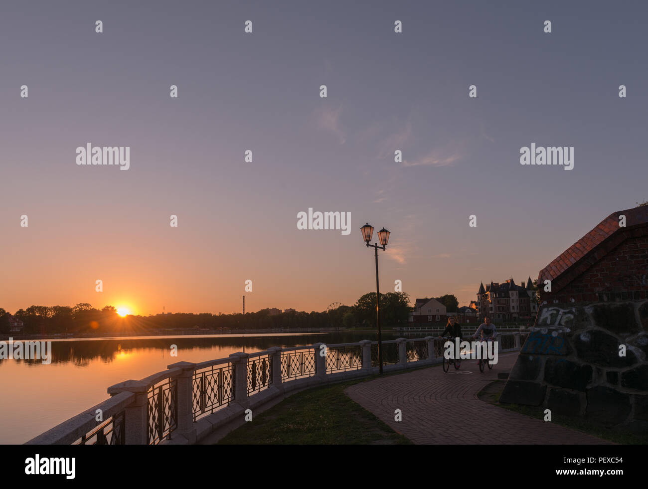 Passeggiata lungo il Obeteich o Lago Superiore, la luce della sera, le ragazze in bici, Kaliningrad, l'oblast di Kaliningrad, Russia Foto Stock