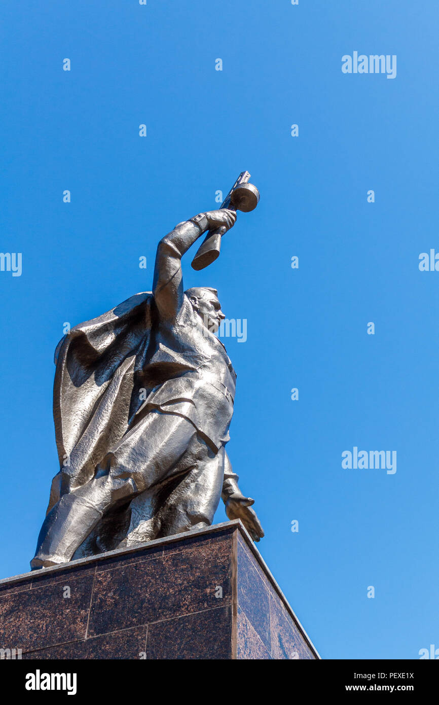 Monumento a un soldato sovietico con un mitragliatore in mano di un partecipante nella seconda guerra mondiale contro un cielo blu. Foto Stock