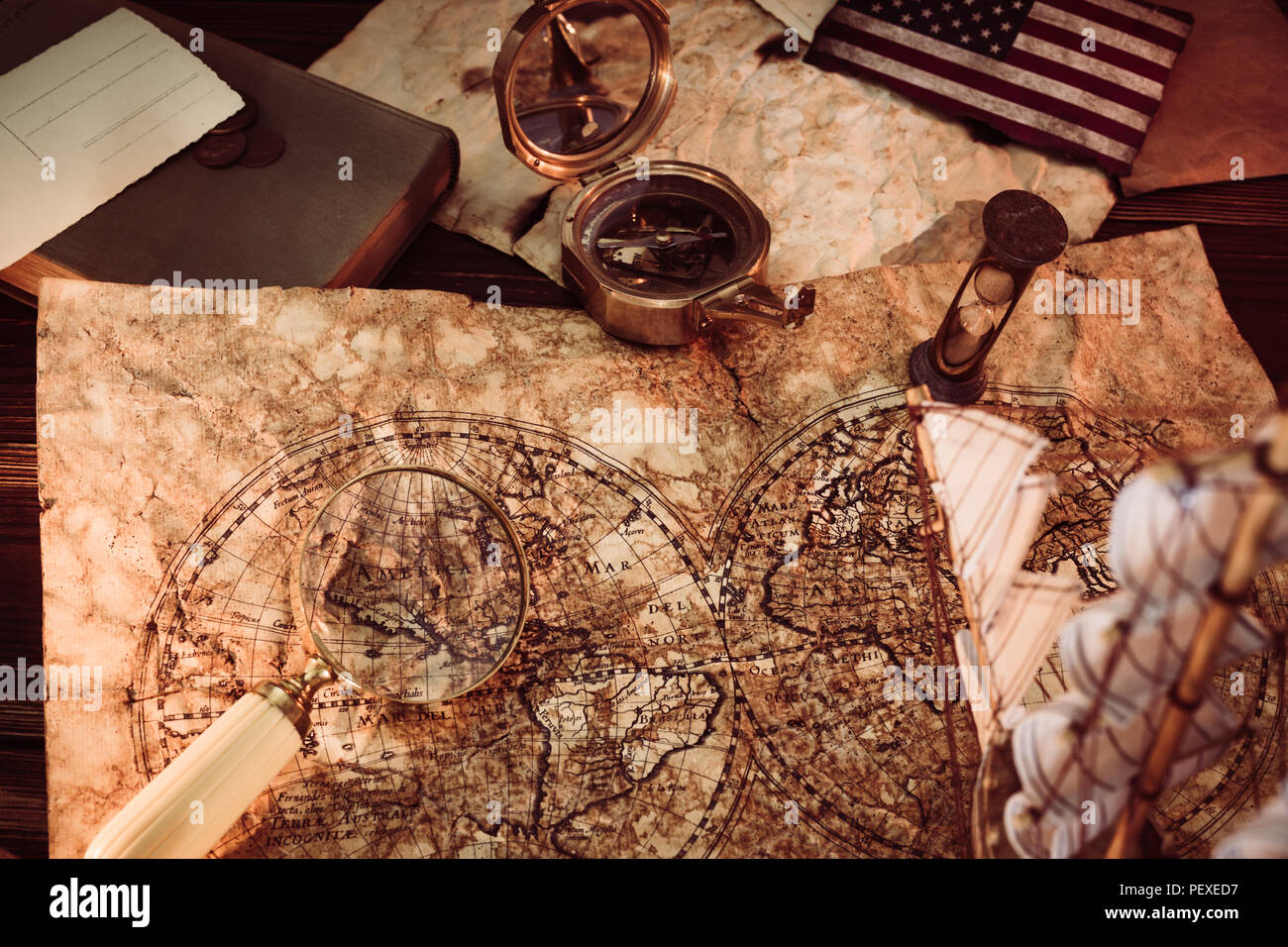 Vecchio vintage mappe e attrezzature marine come bussola, alla lente di ingrandimento o la clessidra e nave. Il Columbus Day concetto. Foto Stock