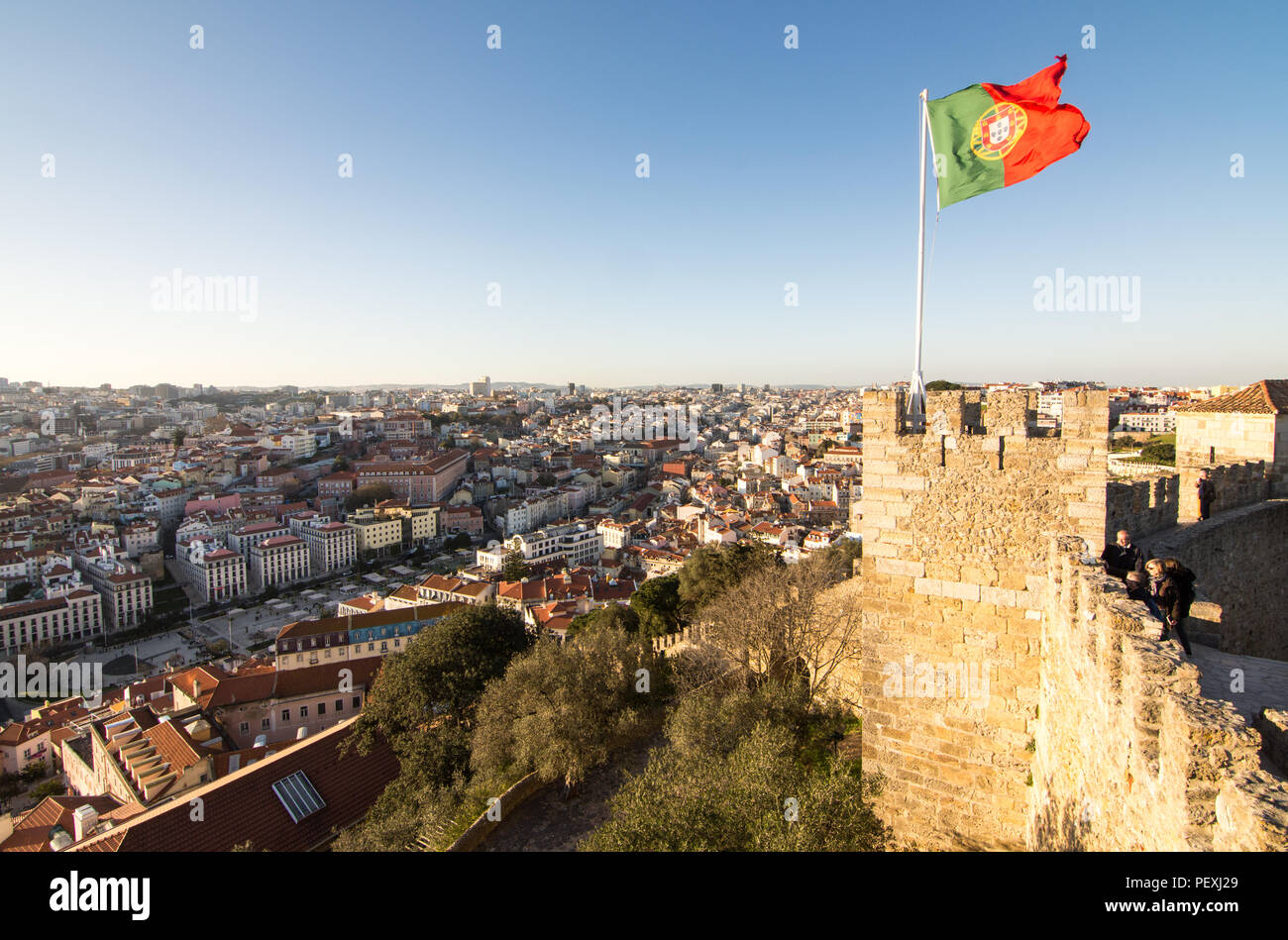 La bandiera portoghese vola dalle pareti della condotta adduttrice di Castelo de Sao Jorge sopra la città di Lisbona. Foto Stock