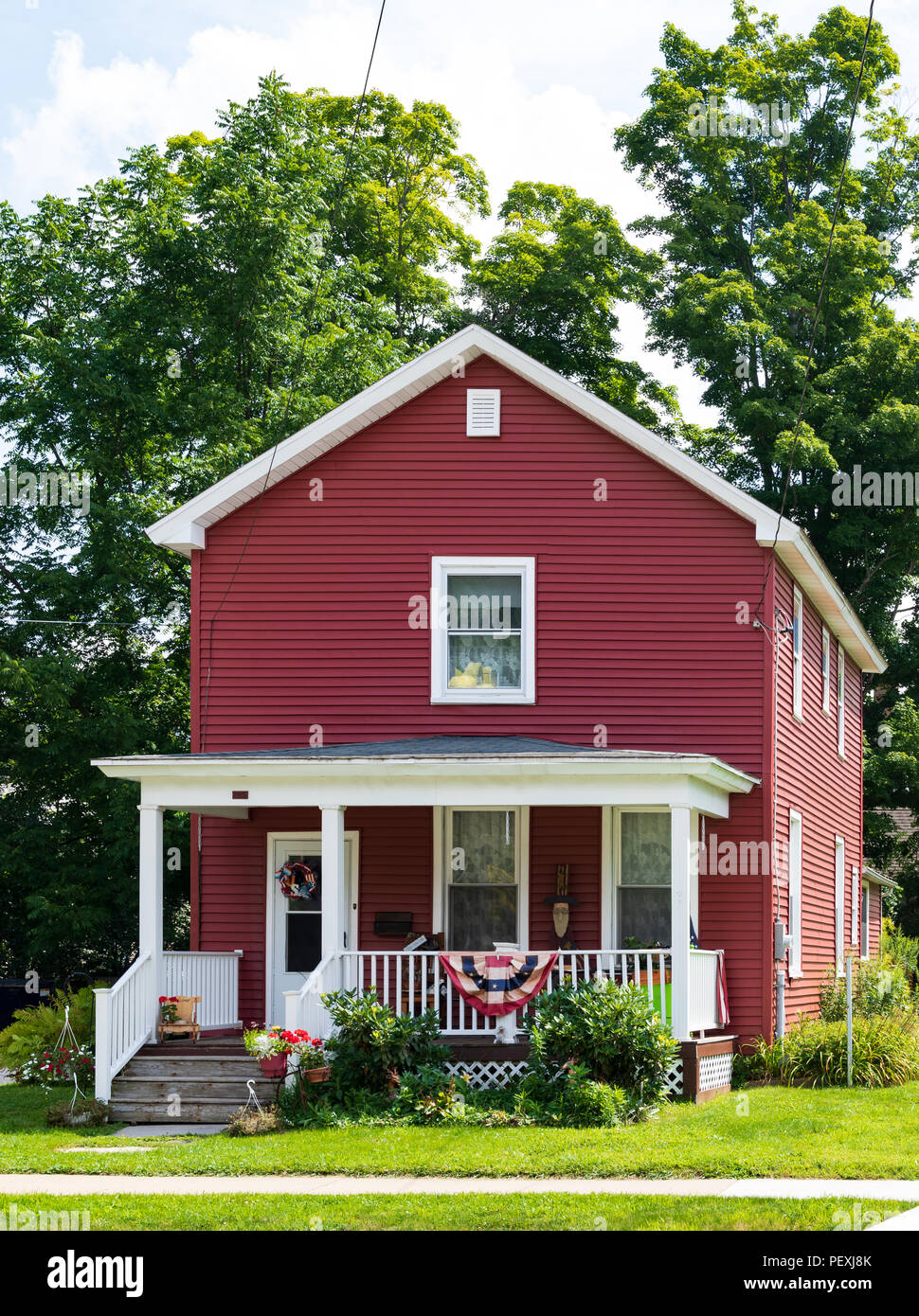 COUDERSPORT, PA, Stati Uniti d'America-10 agosto 18: un rosso 2 Storia di fucile casa di stile con prato curati sulla strada principale del piccolo borgo rurale. Foto Stock