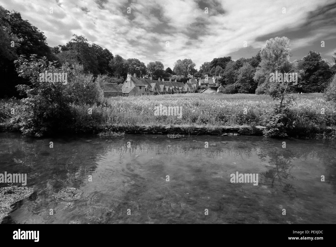 La fila di Arlington cottage in pietra, Fiume Coln, Bibury village, Gloucestershire Cotswolds, England, Regno Unito Foto Stock