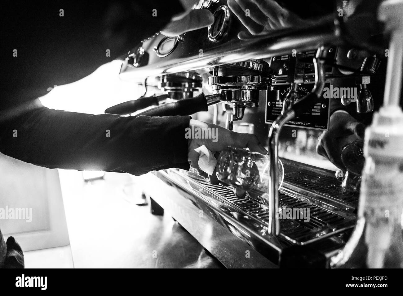La preparazione di caffè espresso BW in bianco e nero close up dettaglio con caffetteria moderna macchina e bicchieri Foto Stock