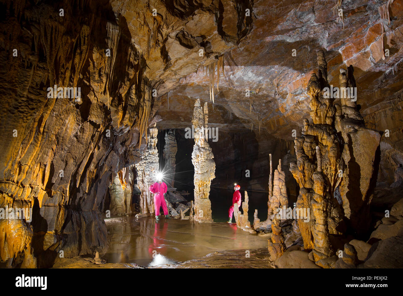 Due uomini stanno esplorando la Krizna Jama grotta. Regione carsica, Slovenia. Foto Stock