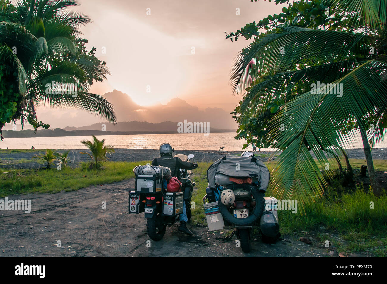 Uomo sulla motocicletta in prossimità spiaggia tropicale, Puerto Viejo, Limon Provincia, Costa Rica Foto Stock