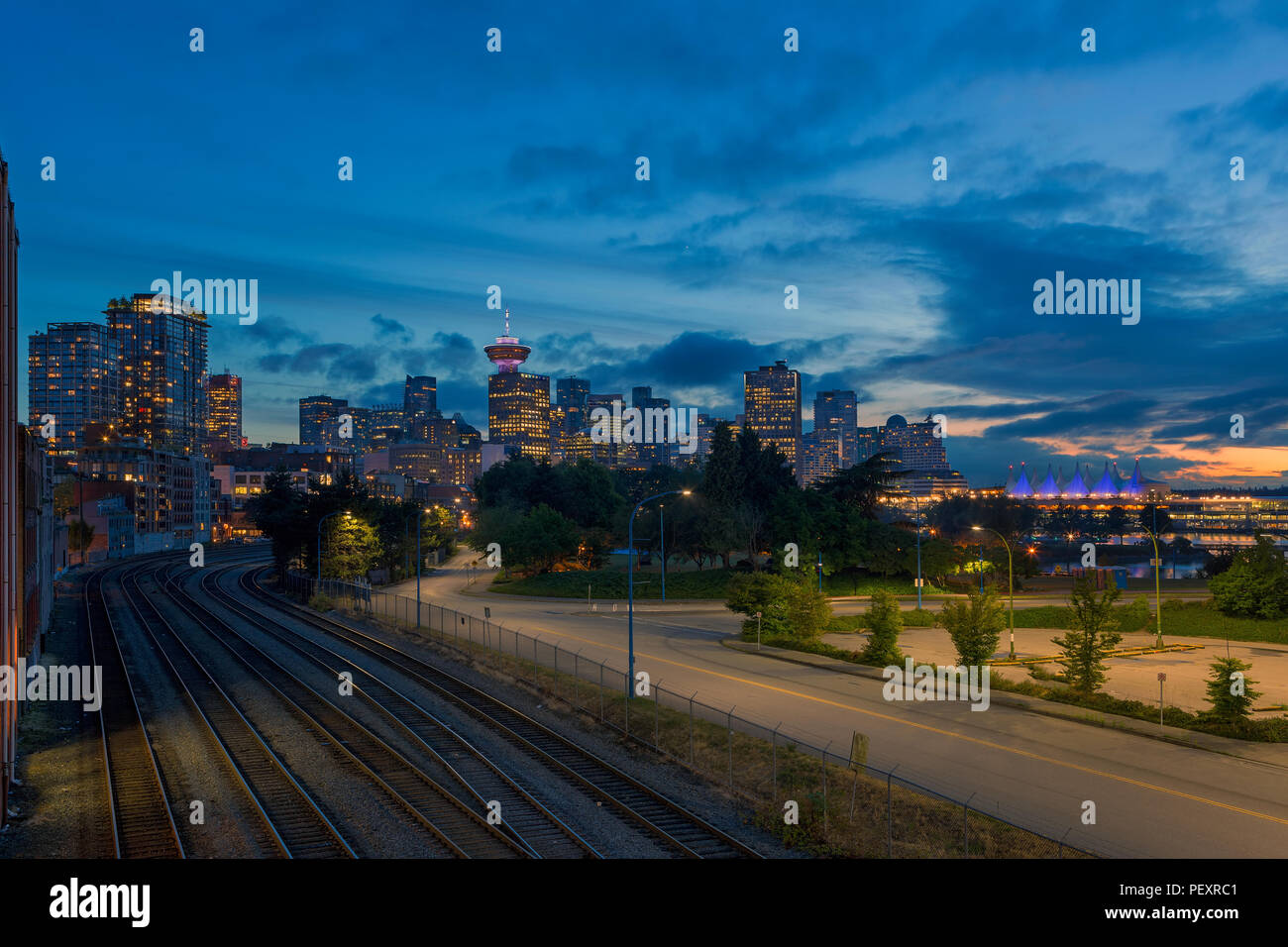 Vancouver BC British Columbia Canada downtown skyline della città da binari ferroviari durante la sera ore blu dopo il tramonto Foto Stock