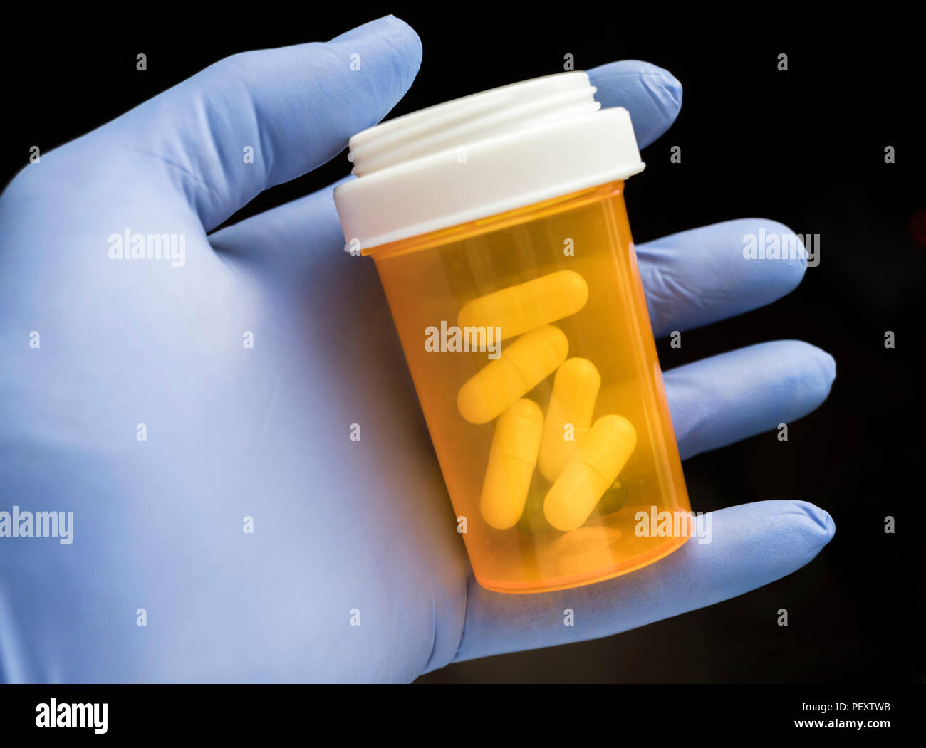 Medico sostiene nella sua mano alcune pillole di bianco Foto Stock