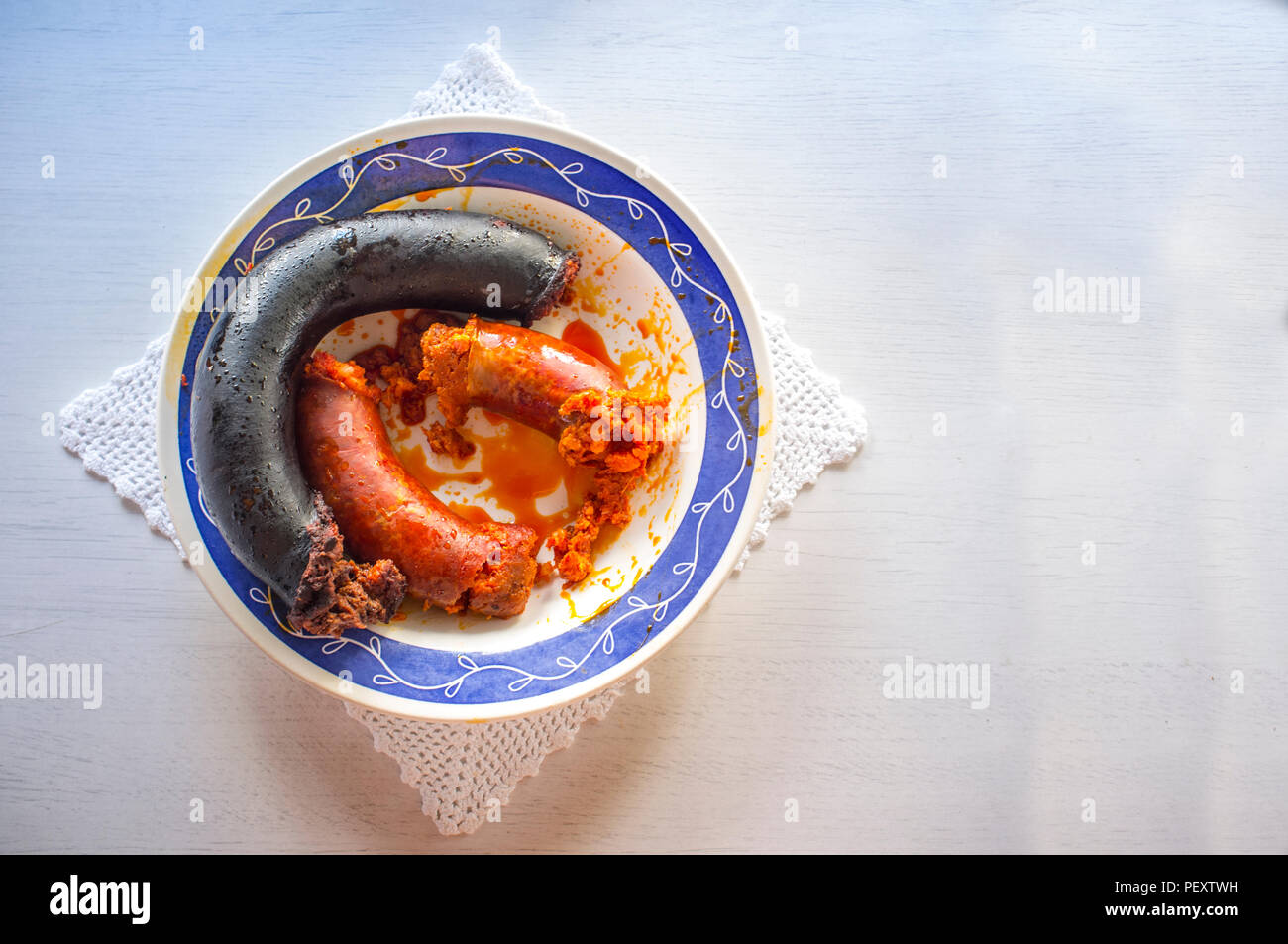 Red chorizo e salsiccia nera morcilla appena cotti su una piastra su un panno di lavorazione a maglia. Primo piano Foto Stock