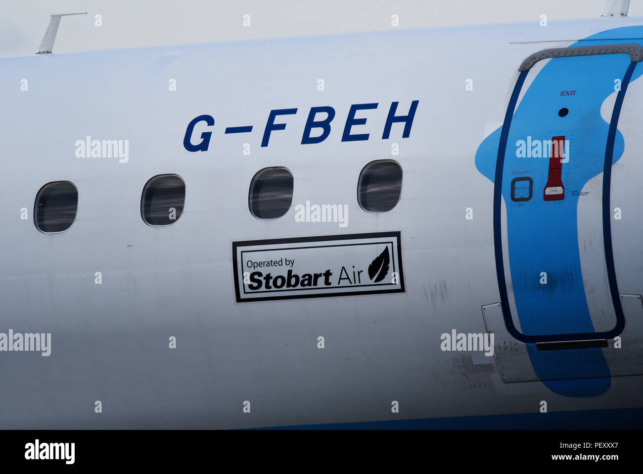 FlyBe Embraer E195 aereo di linea di aeromobili Servizi di piano azionato da aria Stobart. Avviso. Segno. Porta di uscita. Fusoliera lato. G-FBEH Foto Stock
