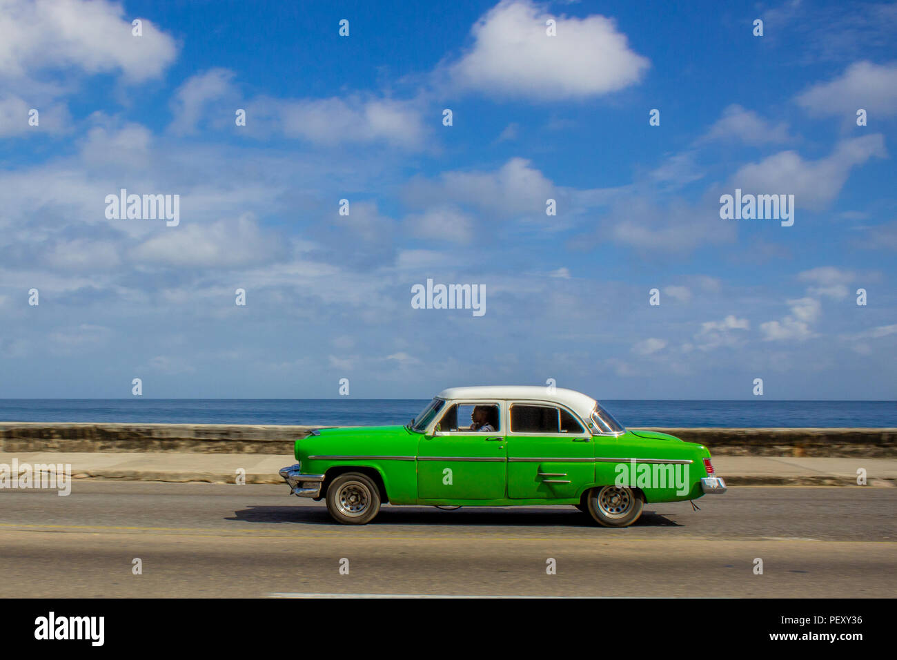 Verde auto guidando lungo il Malecon, Havana Foto Stock