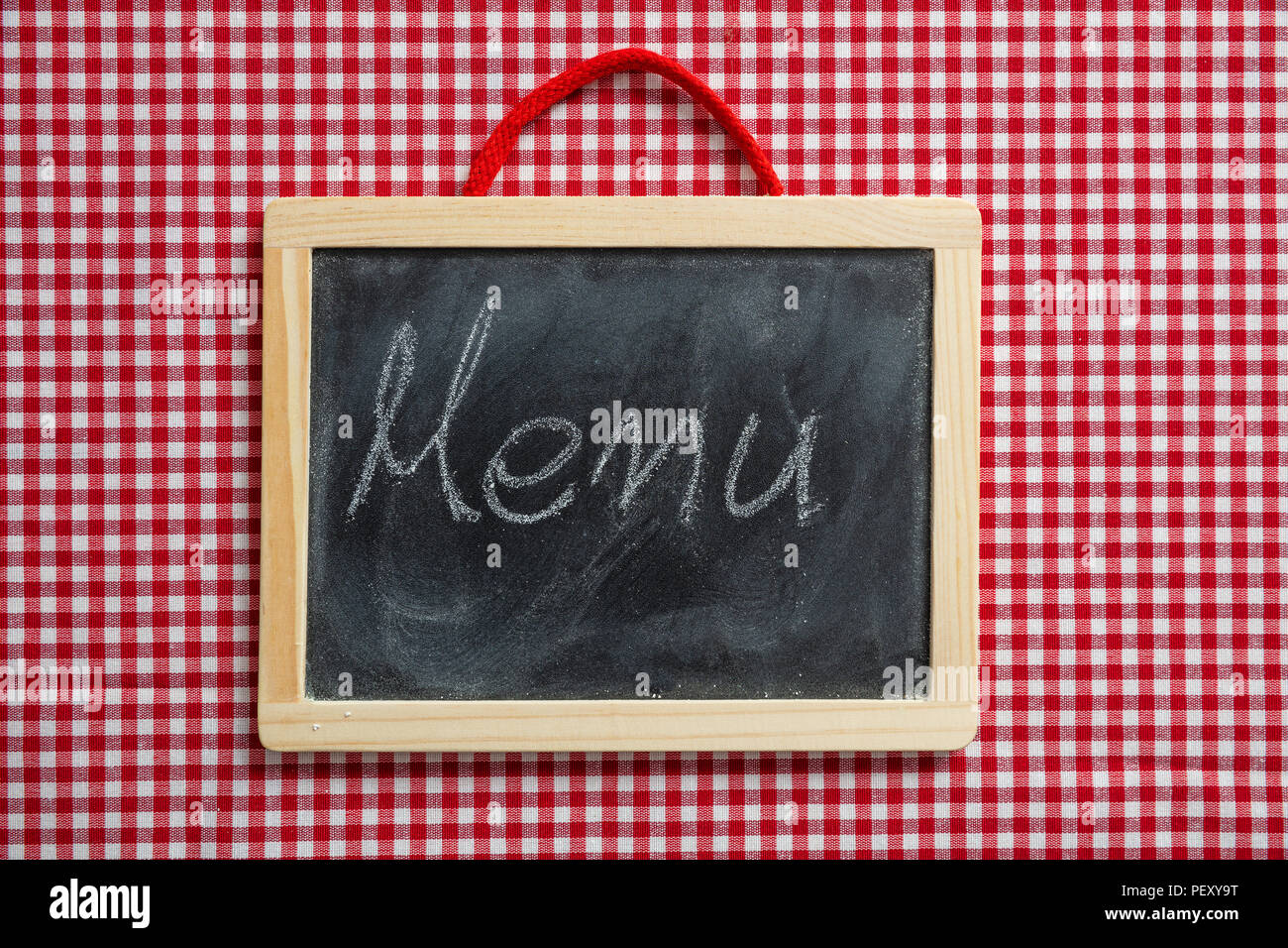 Concetto di menu. Lavagna con il testo scritto a mano menu, rosso a scacchi tovaglia da picnic Foto Stock