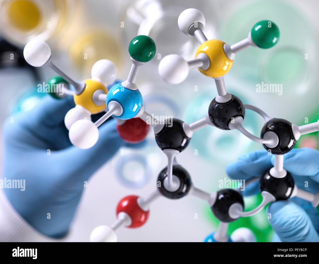 Ricerca di Chimica. Ricercatore la progettazione di una formula chimica utilizzando un modello molecolare. Foto Stock