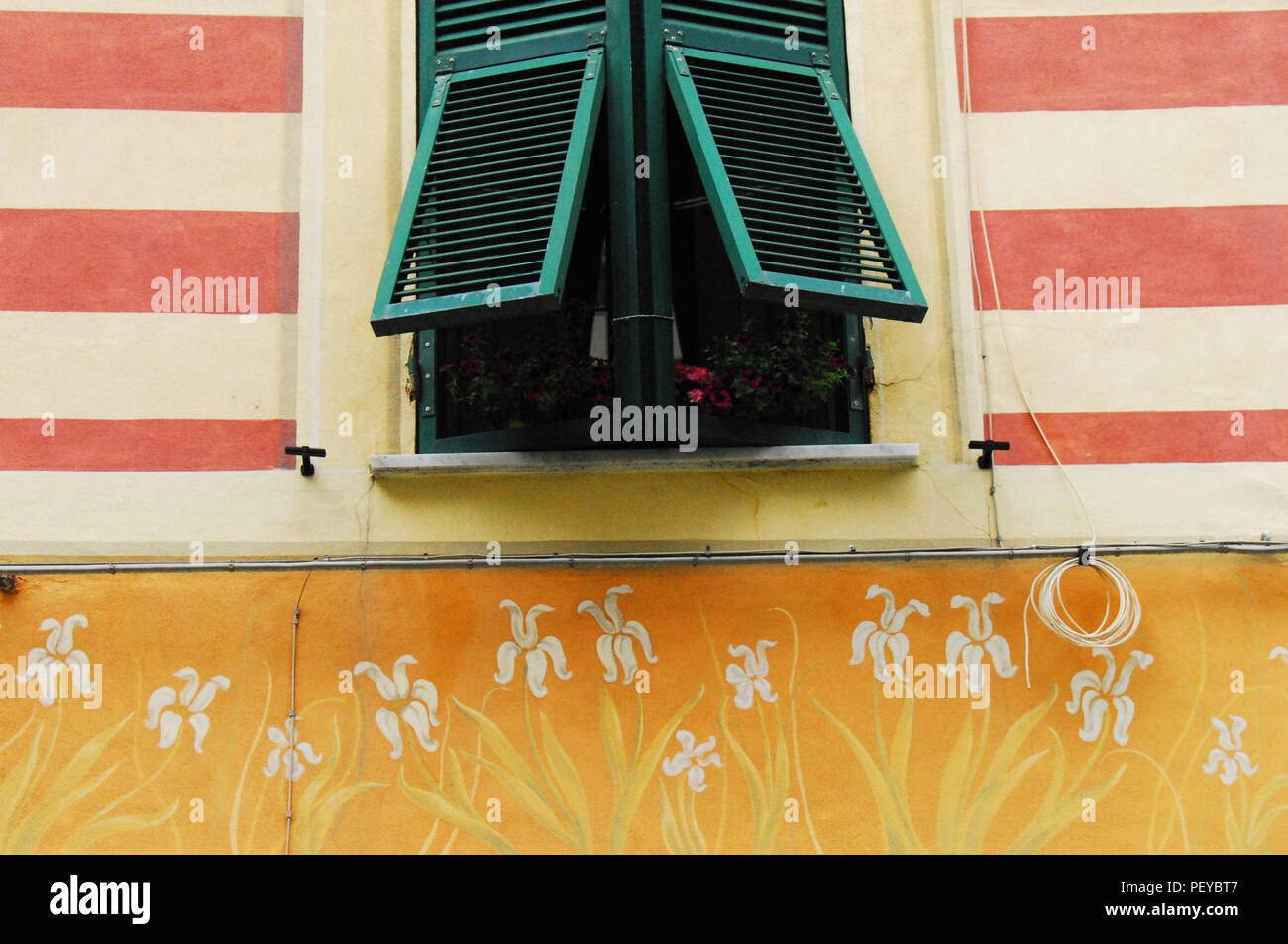 Fantasiosa i dettagli di design con vernice colorata crea una finestra affascinante facciata di questo edificio italiano. Foto Stock
