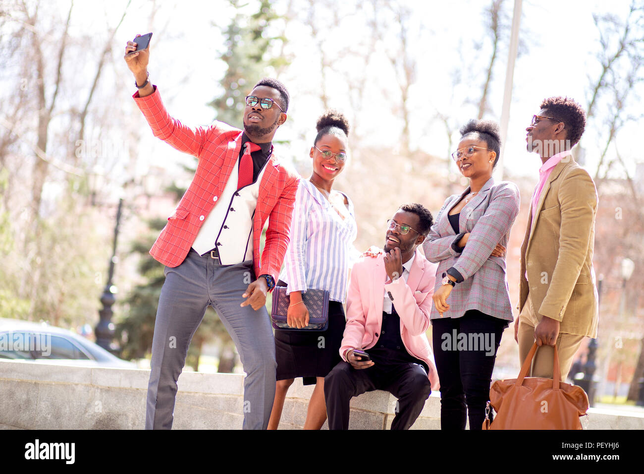 Il gruppo internazionale di persone in abiti eleganti tenendo selfie. Foto Stock