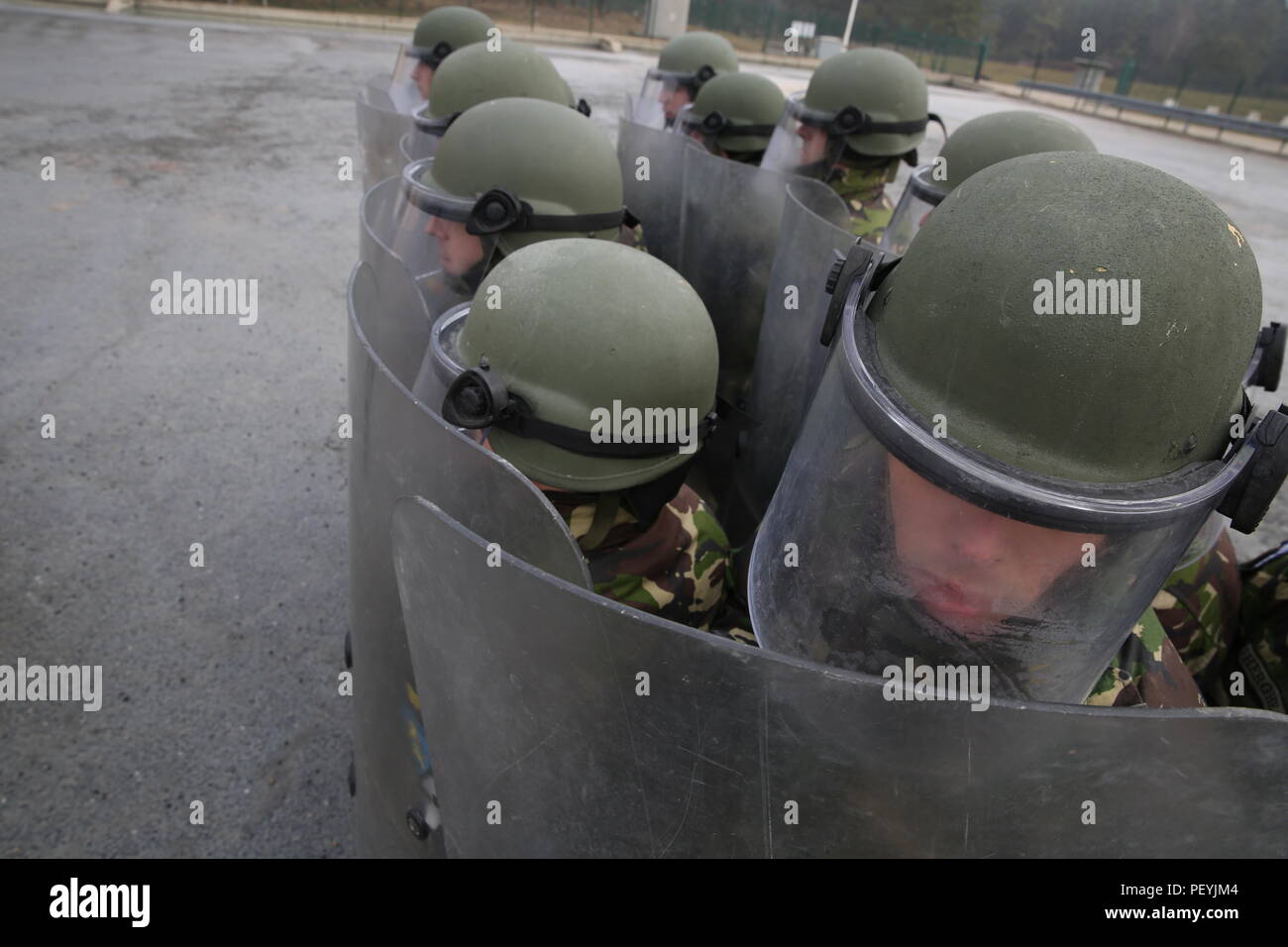 Soldati rumeni di 265Polizia Militare Battaglione protezioni di interblocco durante la conduzione di folla antisommossa durante la formazione di una forza per il Kosovo (KFOR) Missione prove generali di esercizio (MRE) al giunto multinazionale Centro Readiness in Hohenfels, Germania, Feb 18, 2016. La KFOR MRE 21 è basato sull'attuale ambiente operativo ed è progettato per preparare l'unità per il sostegno della pace e della stabilità e le operazioni di emergenza in Kosovo a sostegno delle autorità civili per mantenere un ambiente sicuro e protetto. (U.S. Esercito foto di Spc. Lloyd Villanueva/rilasciato) Foto Stock