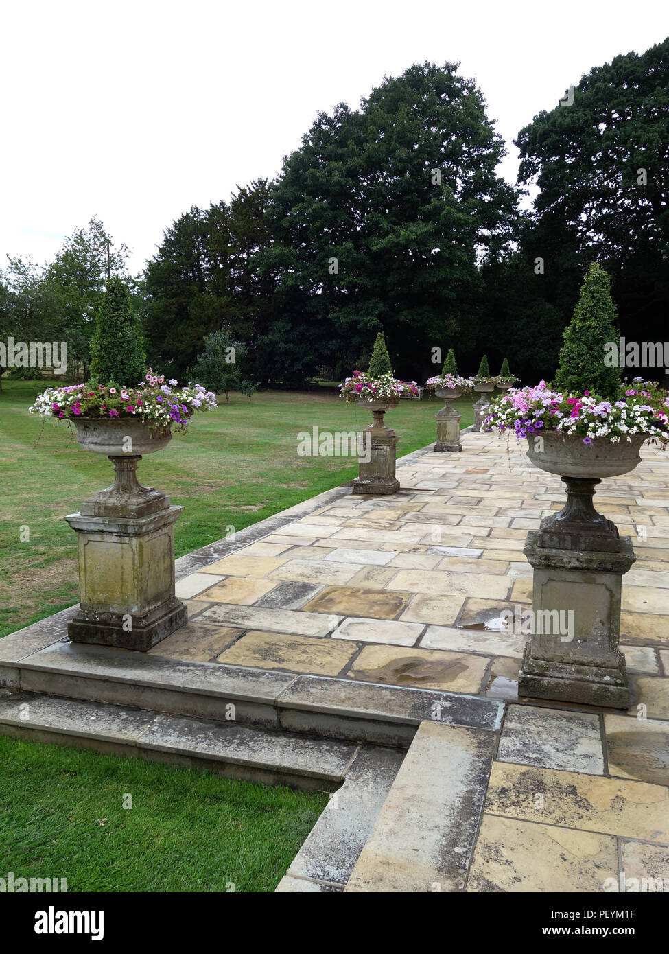 Grecian urne di pietra su aree molto grandi di meraviglioso vecchio reale lastre Yorkstone intorno a un grande privato casa nello Yorkshire. Proprietà rilasciato Foto Stock