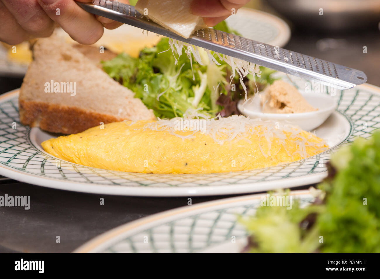 Piastra di frittata con parmigiano rasata su top. Foto Stock