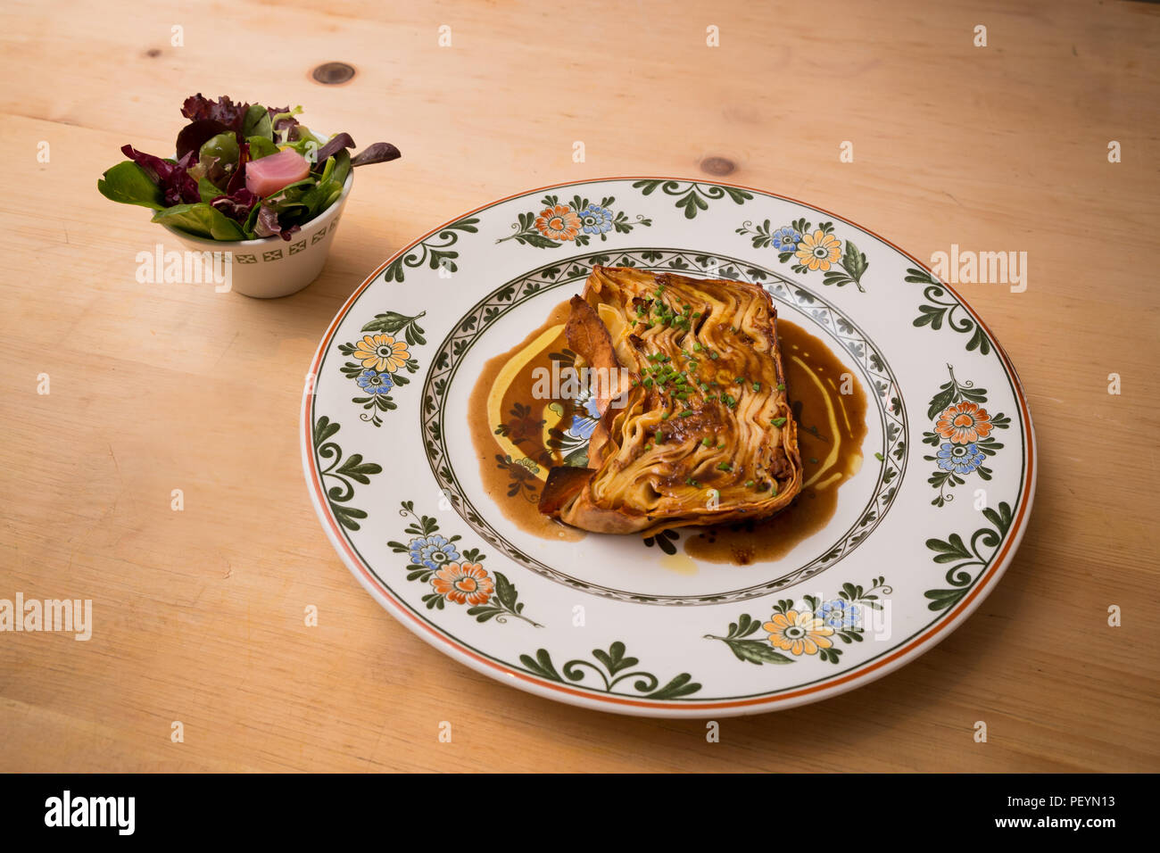 Un piatto di pasta timballo con un'insalata a parte. Foto Stock