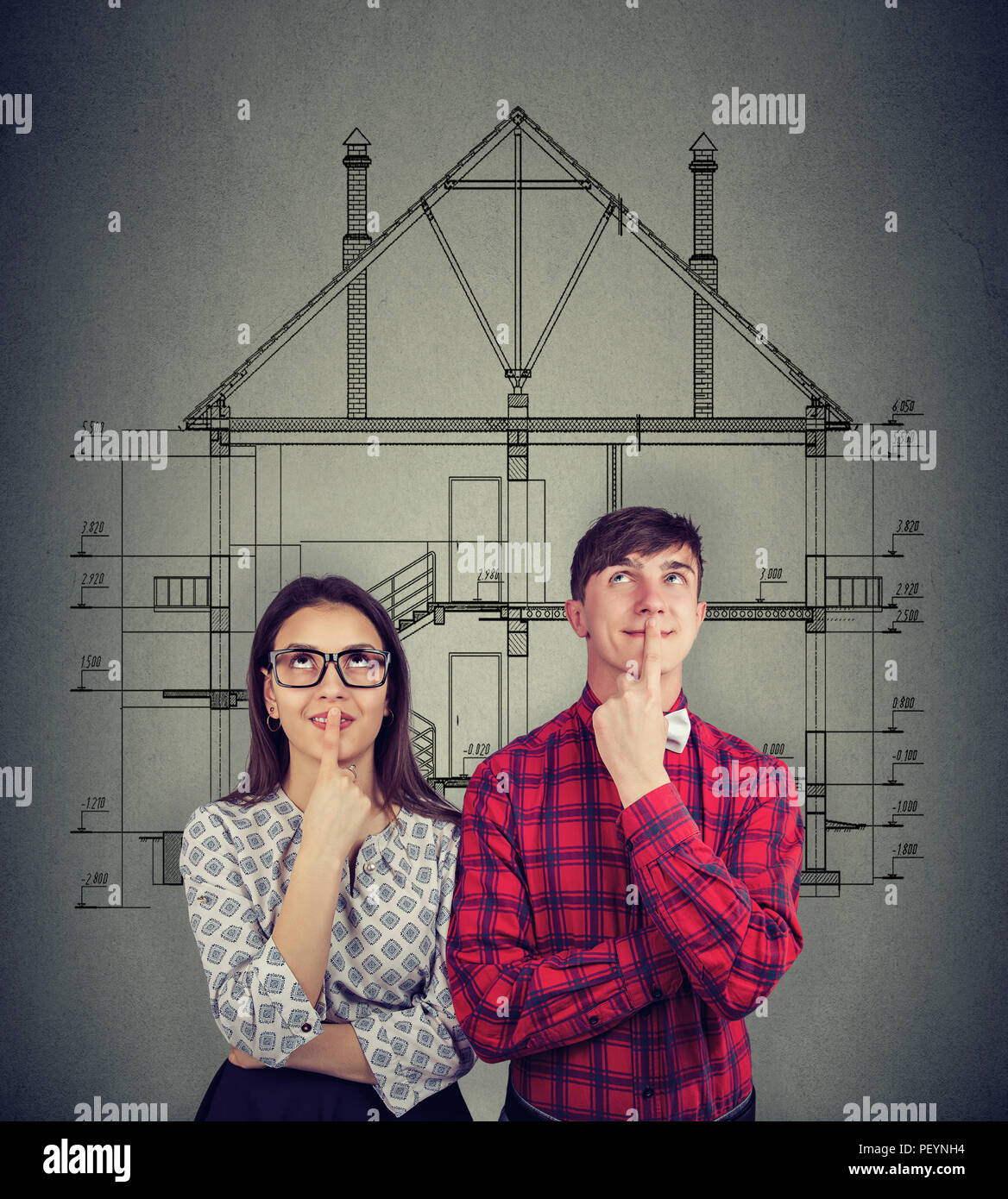 Giovane uomo e donna toccando le labbra e cercando nei sogni di nuova casa sullo sfondo di disegno Foto Stock