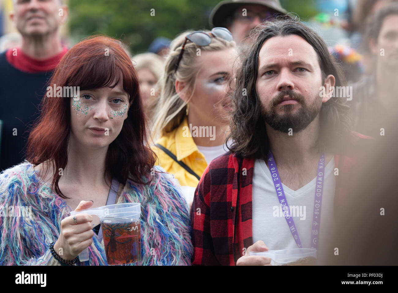 Glanusk Park, Brecon, Galles, 17 agosto 2018. Primo giorno del festival musicale Green Man nelle Brecon Beacons Mountains in Galles. Una giovane coppia di appassionati di musica dall'aspetto fresco beve pinte di birra e guarda il Walled Garden Stage, credito: Rob Watkins/Alamy Live News Foto Stock