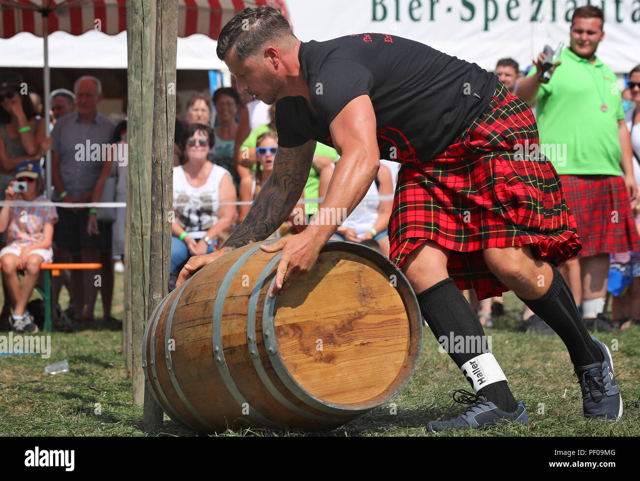 Horgenzell, Germania. 18 Agosto, 2018. Un partecipante della tomaia Highländgames sveva rotoli una canna attraverso un corso di slalom nella disciplina Whiskey cilindro di laminazione. Squadre di tutta la Germania meridionale hanno gareggiato gli uni contro gli altri in varie discipline. Credito: Karl-Josef Hildenbrand/dpa/Alamy Live News Foto Stock