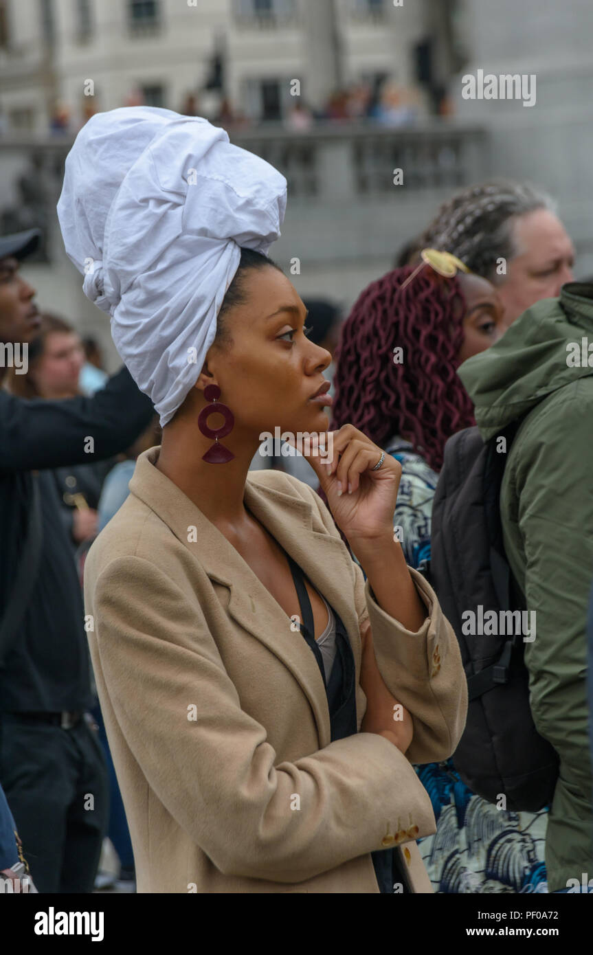 Londra, Regno Unito. Il 18 agosto 2018. Una donna in un tradizionale africano vestito di testa alla nazionale annuale manifestazione commemorativa in Trafalgar Square ricorda e onora le vittime dell'Olocausto africano/tratta degli schiavi transatlantica e internazionale promosso dalla schiavitù Giorno del Ricordo, 23 agosto. L'evento chiamato per gli africani per celebrare la loro identità e per ricordare i loro antenati, e iniziò con libagioni ricordando molti eroi nero. ers ha parlato il disco Credito: Peter Marshall / Alamy Live News Foto Stock