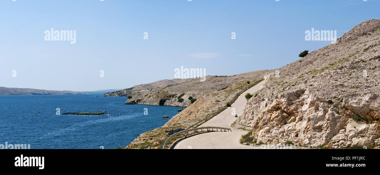Croazia, Europa: una tortuosa strada giù per il beach sull'isola di Pag, la quinta più grande isola della costa croata del Mare Adriatico settentrionale Foto Stock