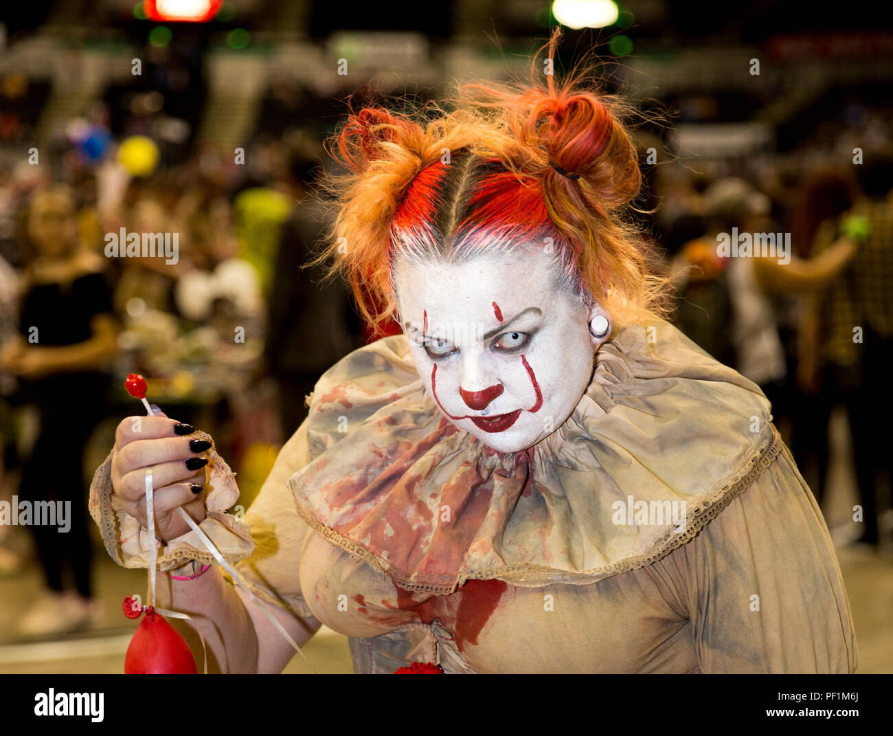 Una femmina di cosplayer vestito come Pennywise il clown da Stephen King Novembre e guardare il male e minaccioso a un fumetto con evento Foto Stock