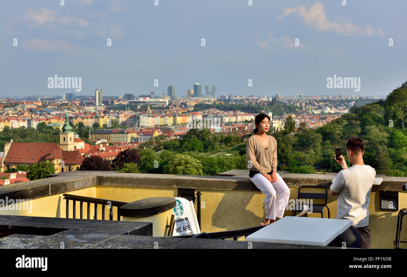 Turistica prendendo le foto di donna amico affacciato sulla città di Praga, Repubblica Ceca Foto Stock
