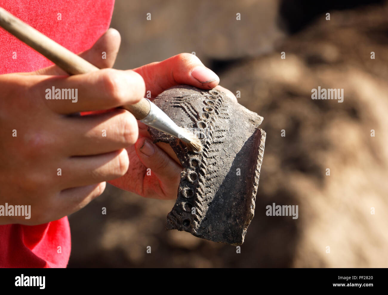 Archeologo maniglie con cautela la scoperta - parte medievale di recipiente di argilla.Il modello consente agli scienziati di data la ricerca Foto Stock