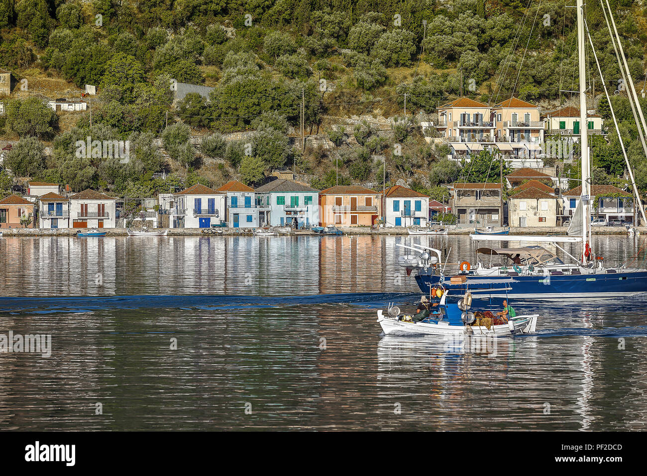 Vathi: luglio XII . I pescatori greci di entrare nel porto e e barca a vela in uscita. Ingresso di Itaca Vathi nel Mar Ionio. 12 luglio 2016 Ithaca Foto Stock