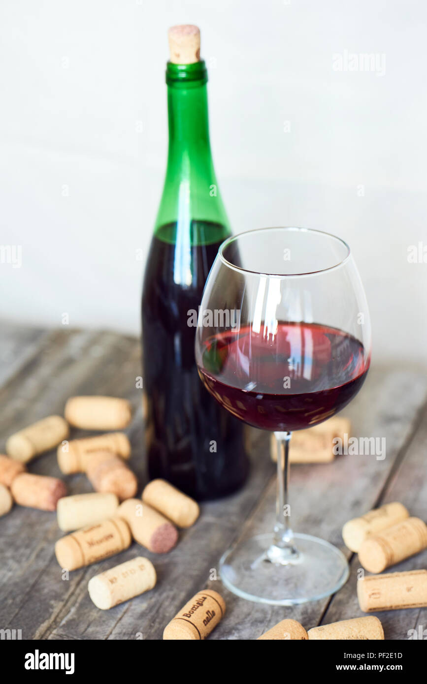 Bicchiere di vino rosso e delle bottiglie con tappi di sughero Foto stock -  Alamy