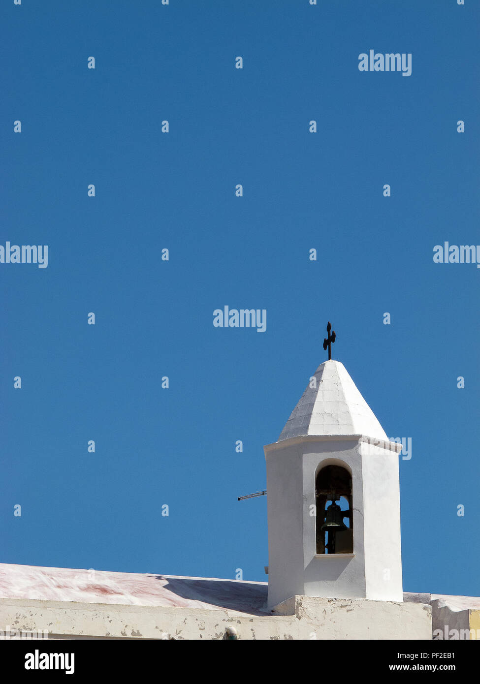 Calabria (Italia): bianco piccolo campanile sul tetto di una chiesa con il blu del cielo senza nuvole sullo sfondo, in una soleggiata giornata estiva Foto Stock