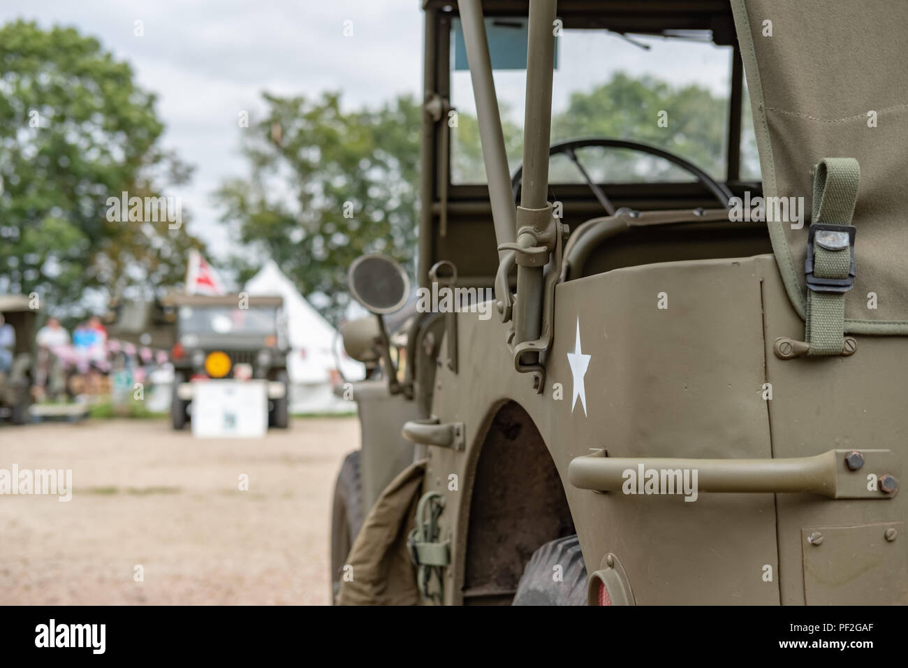 Messa a fuoco superficiale, immagine isolata di una jeep dell'esercito americano della seconda guerra mondiale, vista essere stata restaurata. La stella verniciata e lo sterzo sono visibili su questo veicolo iconico. Foto Stock