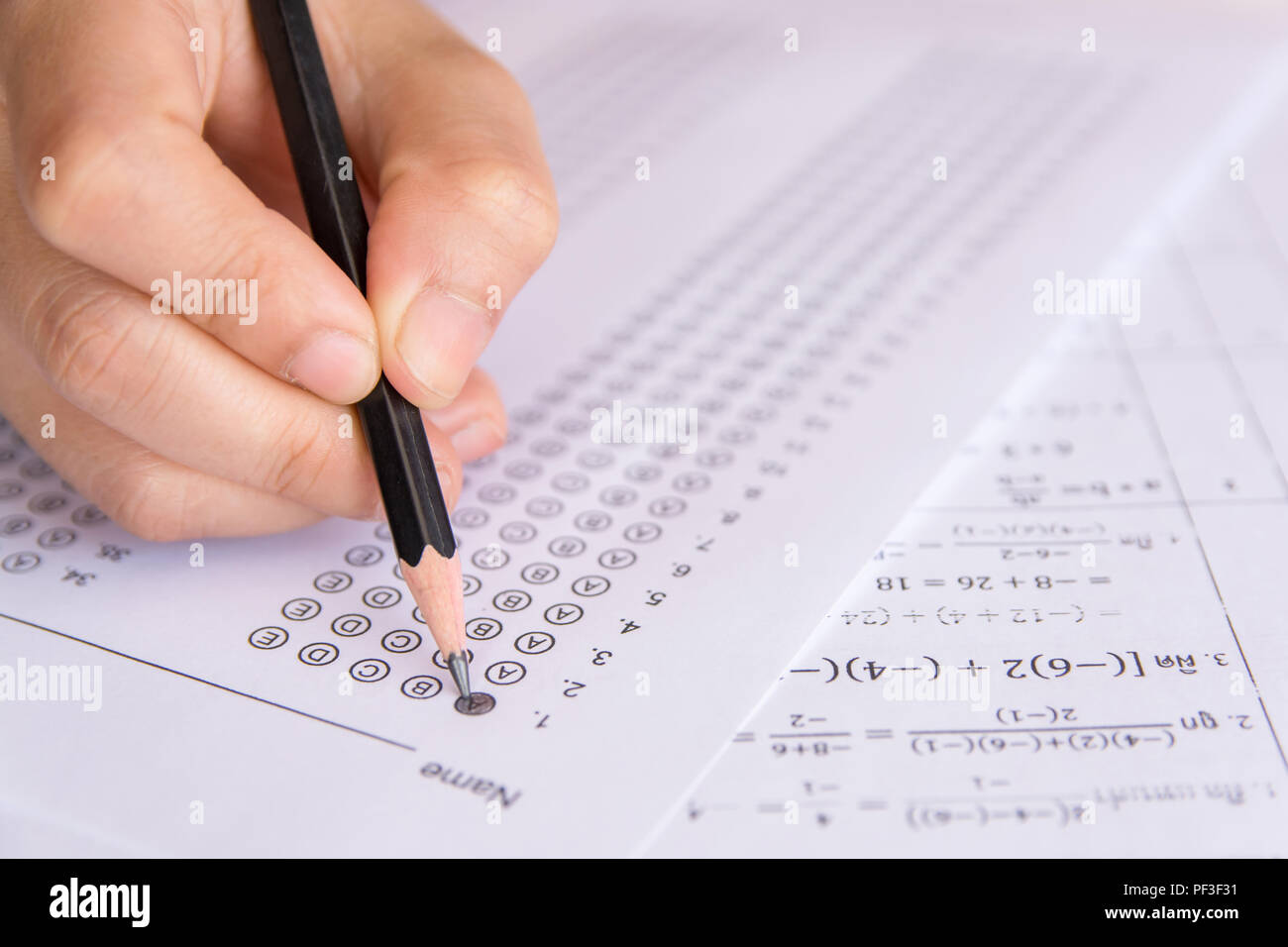 Gli studenti mano azienda matita scelta selezionata su fogli di risposta e matematica questione fogli. Gli studenti facendo prova di esame. esame scolastico Foto Stock