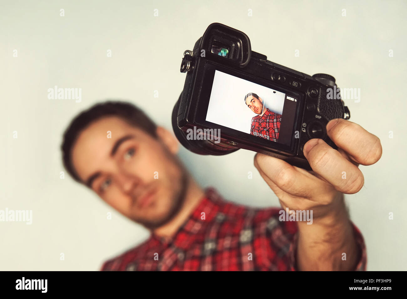 Ritratto di auto di allegro, barbuto blogger in maglietta selfie ripresa, rendendo il video per il suo blog su sfondo giallo. bel giovane uomo prendendo pictu Foto Stock