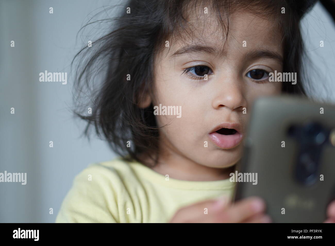 Baby girl utilizzando un telefono cellulare Foto Stock