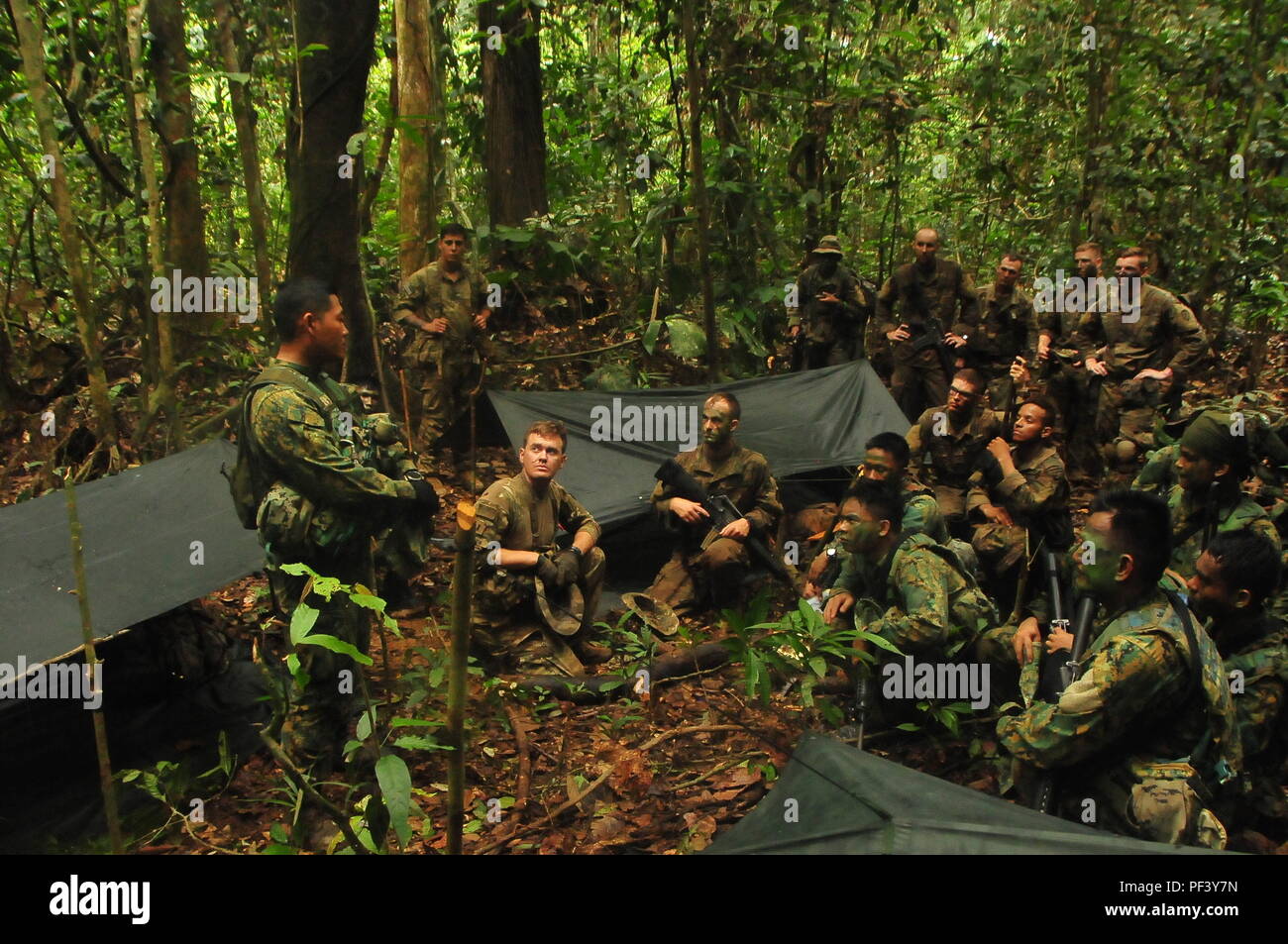 PENANJONG GARRISON, Brunei- un soldato con il primo battaglione, Royal Brunei Forze terrestri, incarica un soldato assegnato al primo battaglione, 151st Reggimento di Fanteria, Indiana Esercito Nazionale Guardia, durante la conduzione di guerra nella giungla operazioni durante l'esercizio Pahlawan Warrior in un luogo conosciuto come MB 20 all'interno del Borneo pianura foreste pluviali regione, Brunei, 11 agosto 2018. Questa è la prima armata-esercizio dell'esercito tra i RBLF e U.S. Esercito. Soldati RBLF formazione led PER STATI UNITI I soldati durante la guerra nella giungla delle operazioni e U.S. I soldati hanno assunto la leadership training soldati RBLF sulle operazioni militari in te urbana Foto Stock