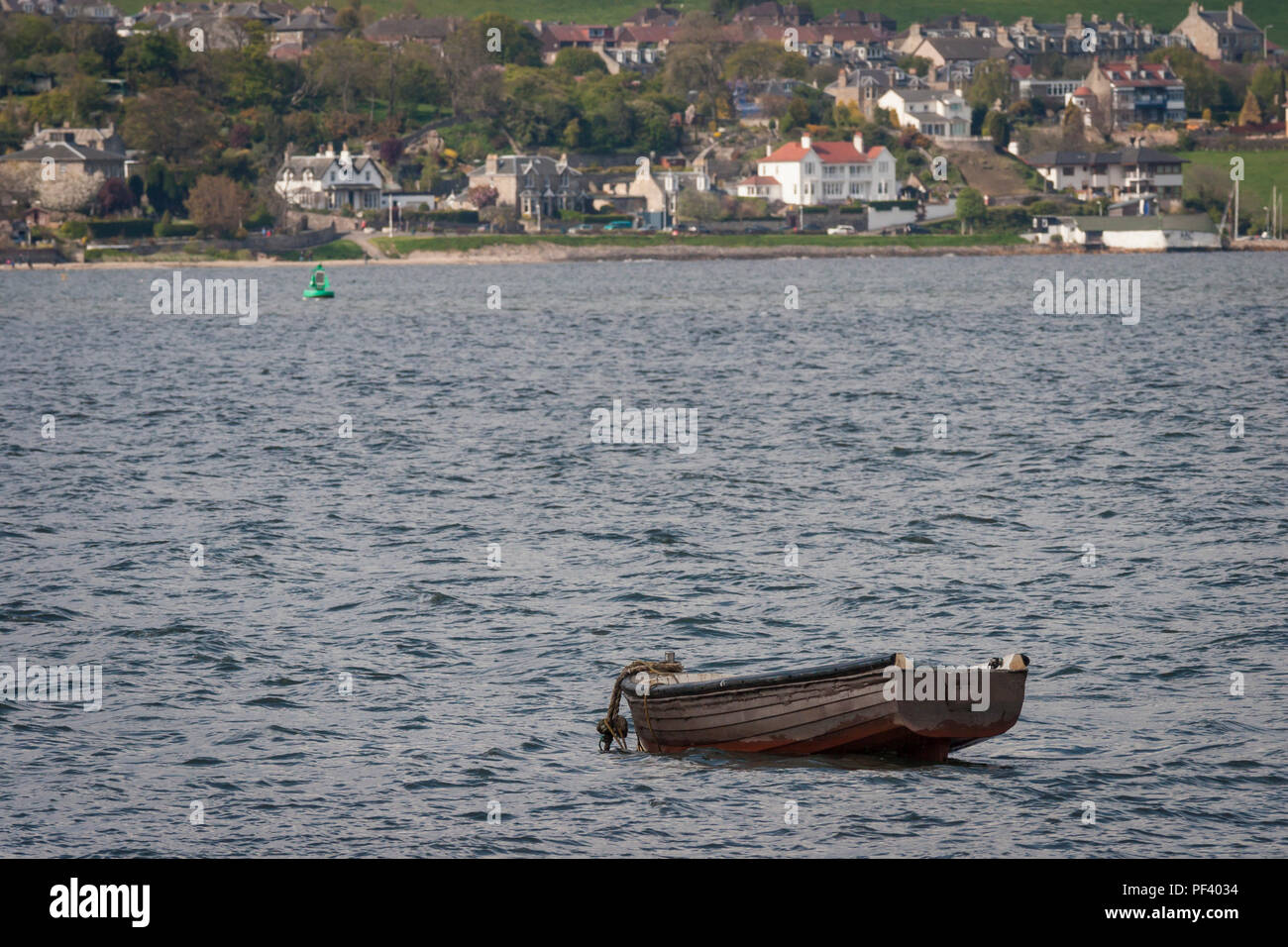 Piccola barca fluttuante nel Firth of Forth Foto Stock