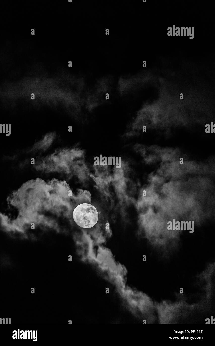 Luna piena nel mezzo di nuvole Foto Stock