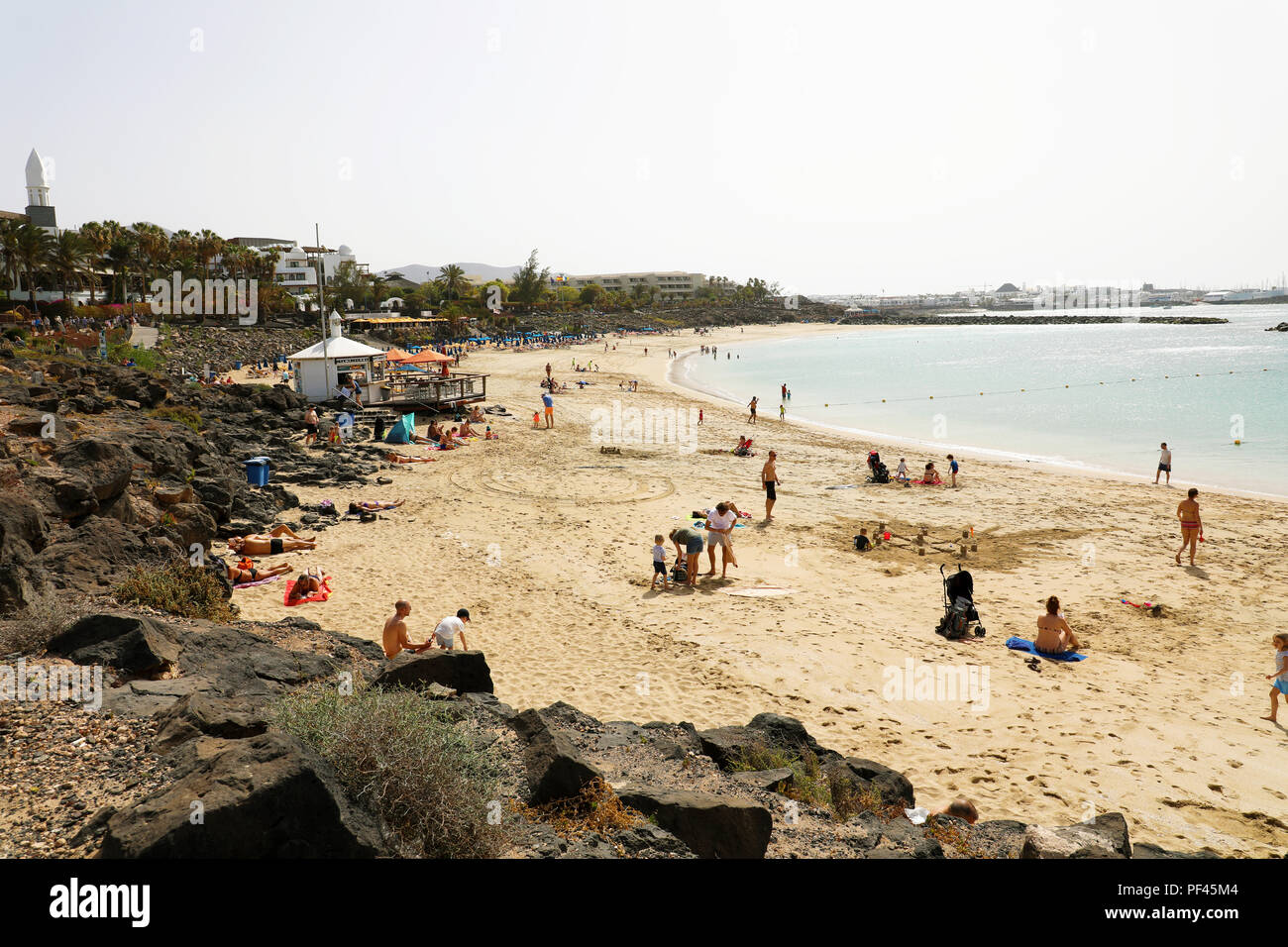 LANZAROTE, Spagna: 18 Aprile 2018: la splendida vista di Playa Dorada Beach con i bagnanti sulla sabbia, Lanzarote, Isole Canarie Foto Stock