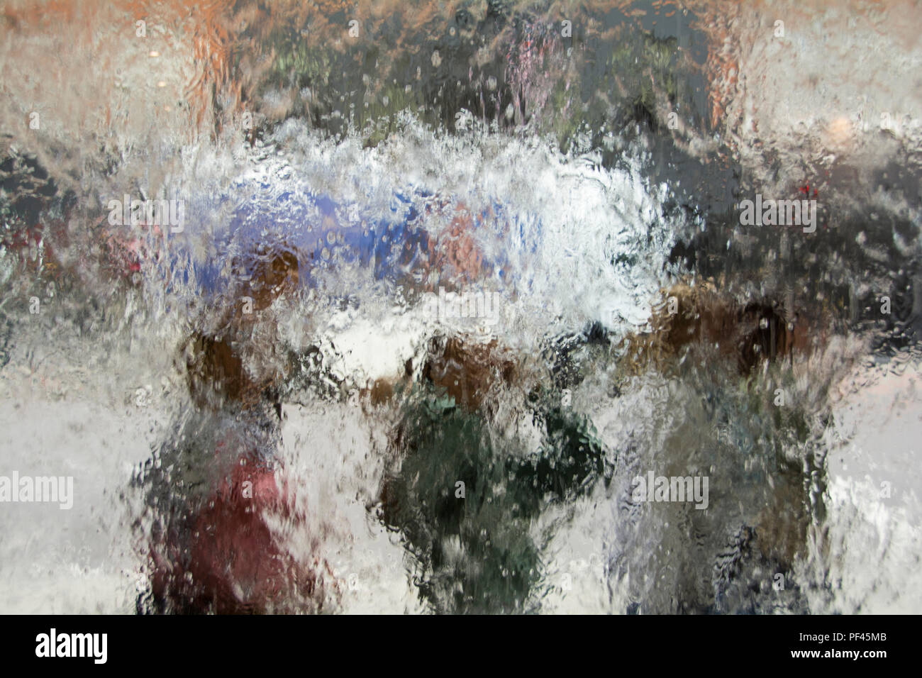 Un gruppo di persone sotto la pioggia - acquosa sfondo astratto Foto Stock