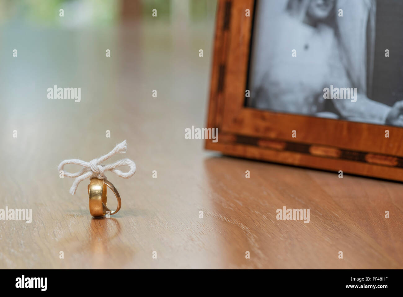 Due anelli d'oro uniti con alcuni lo spago, simboleggia la coppia essendo jpoined nel matrimonio. Foto Stock