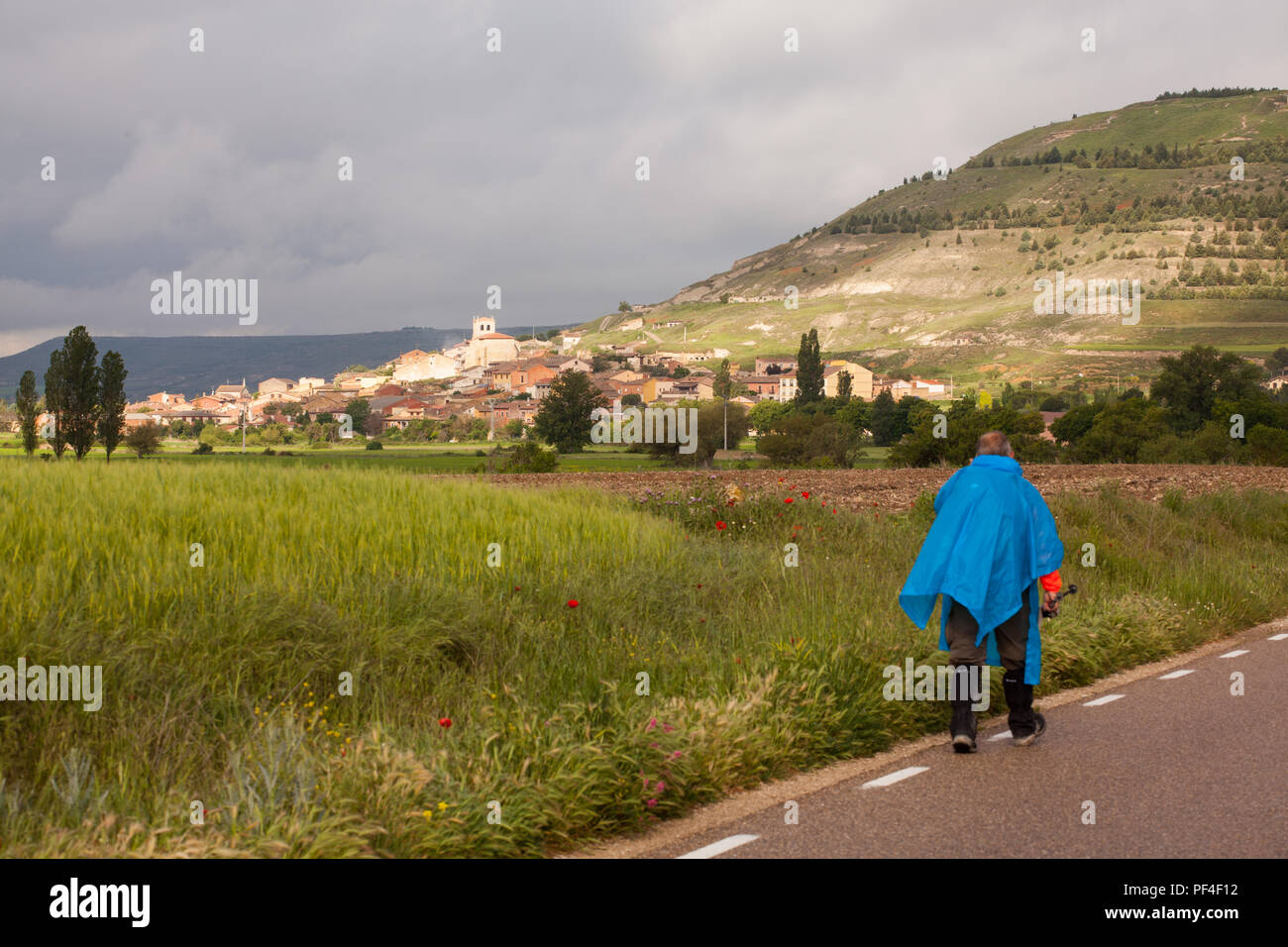 Uomo pellegrino a che si avvicina alla città spagnola di Castrojeriz mentre si cammina il Camino de Santiago la via di San Giacomo pellegrinaggio Spagna Foto Stock