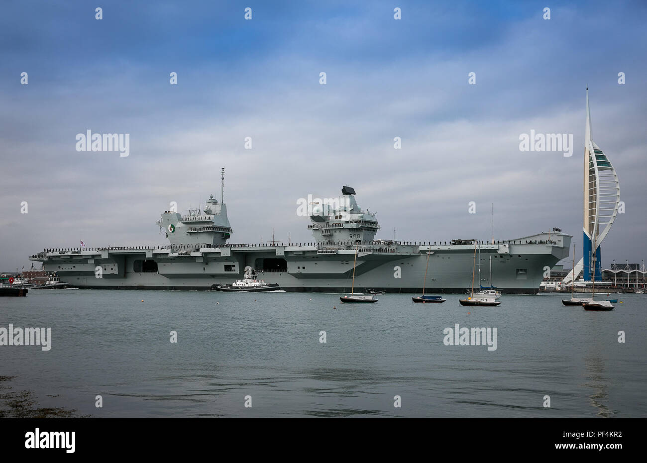 Portsmouth, Regno Unito. 18 Agosto, 2018. La Royal Navy di ultima portaerei HMS Queen Elizabeth lasciando Portsmouth Base Navale. Ella è voce negli Stati Uniti per un periodo di quattro mesi di prove in mare, un viaggio che vedrà l'introduzione dell'F35B aerei da combattimento per il suo ponte per la prima volta. Credito: David Betteridge/Alamy Live News Foto Stock