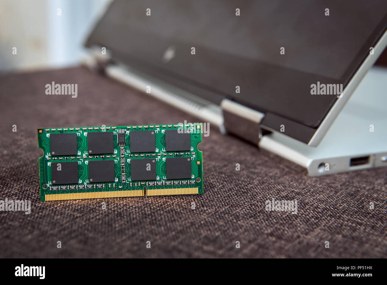 Scheda di memoria RAM per computer portatile sullo sfondo di un  laptop-trasformatore ripiegato a tavoletta. Memoria DDR per gadget moderni.  La riparazione di un computer. Aumentare la amoun Foto stock - Alamy