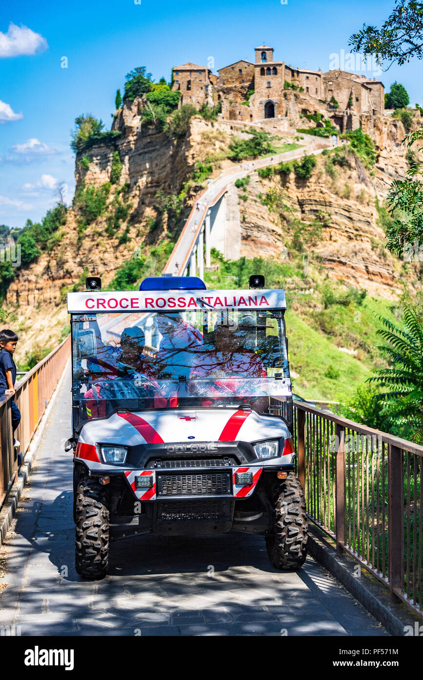 Un'ambulanza specializzata 4x4 evacua un turista con un'emergenza medica da Civita di Bagnoregio, attraverso il suo famoso ponte ad un'ambulanza in attesa. Foto Stock