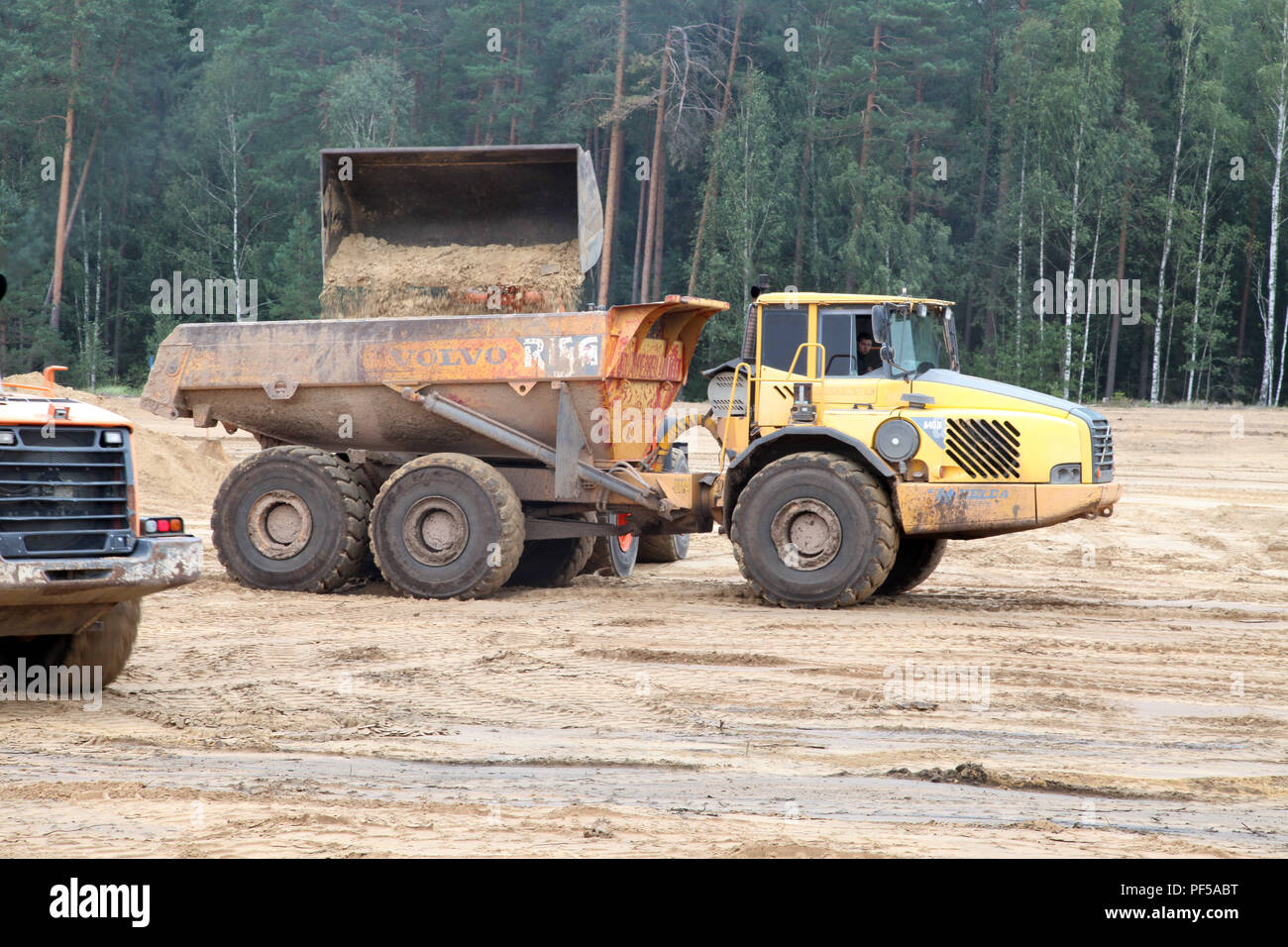 Cinque iarde cubiche di sporcizia caricati in camion a Ottieni in prestito la buca su Kurza Ruda AB mentre implementata per la formazione di costruire un'aria-terra di gamma per essere usato dalla NATO e le forze lituano, Agosto 16, 2018. Foto Stock