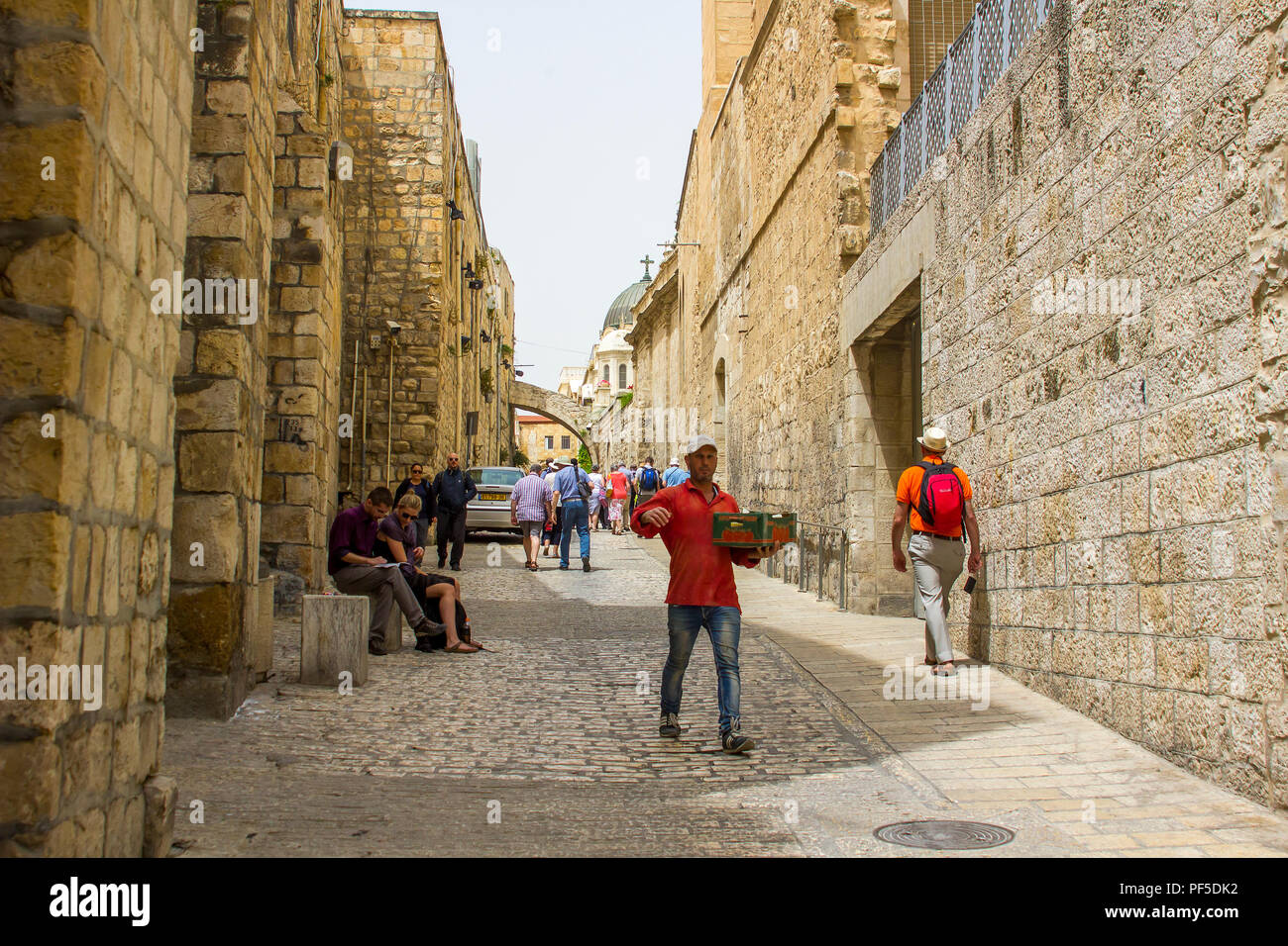 11 maggio 2018 un uomo musulmano a piedi mentre trasporta una piccola scatola di merci su una stretta strada laterale per la Via Dolorosa in Gerusalemme Israele Foto Stock
